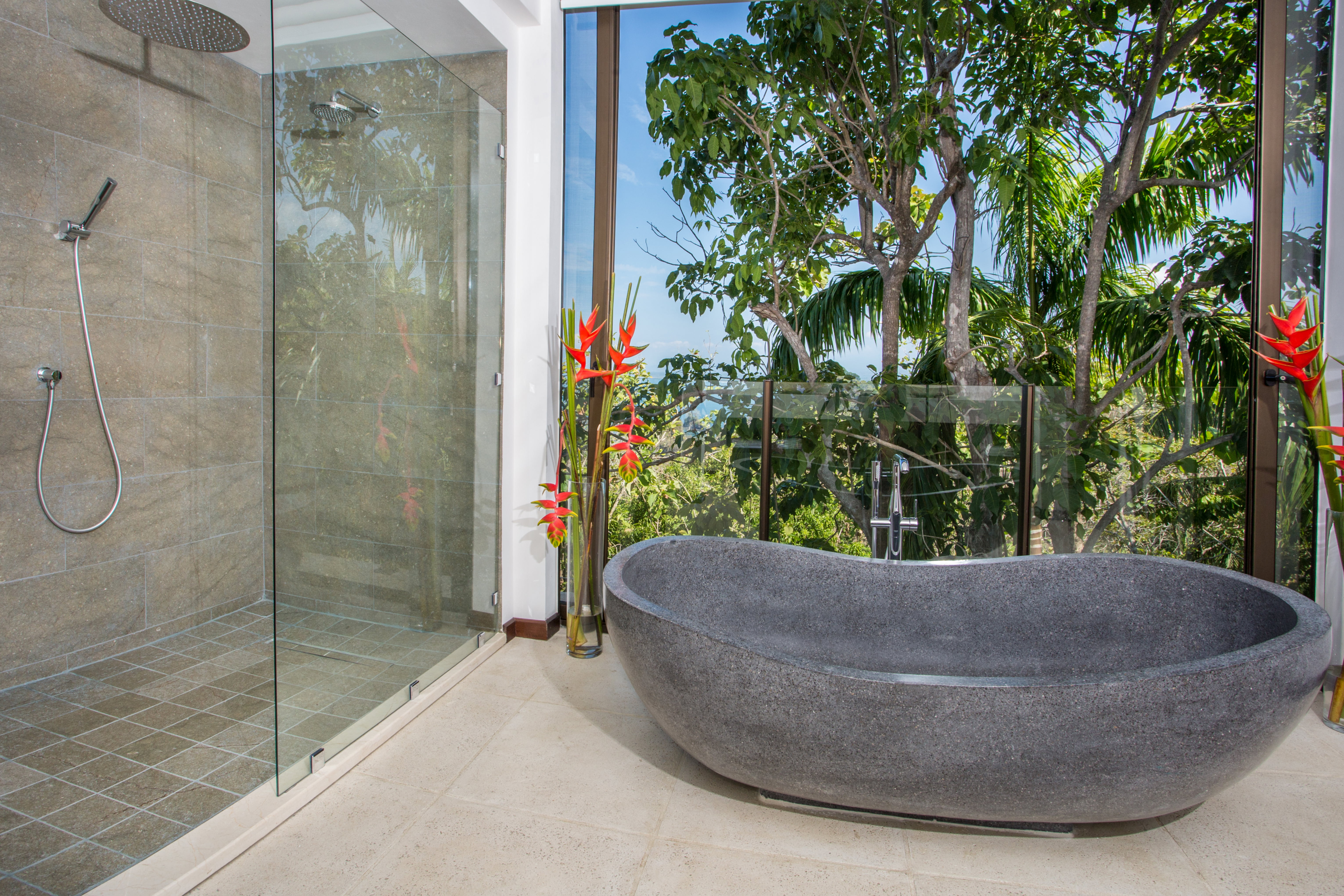 The glass walls open the bathroom to the jungle below